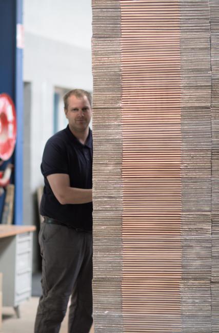 Employé manœuvrant une pile de cartons prête pour l'expédition